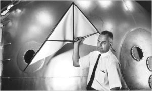 Francis Rogallo posing with his Rogallo Wing beside a NASA reentry capsule.