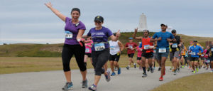 Runners passing the Wright Brothers Monument. Photo, Outer Banks Sporting Events