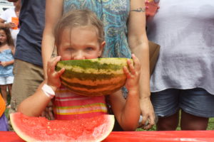 A hungry participant munches on her watermelon