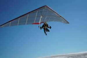 A hang glider flying above the cold snow